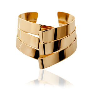 This Shield bracelet peeks out of your sleeve. It's your go-to daily bracelet, elegant, classic and beautiful. Wear two and you will be a wonder woman!  ~1.5" wide  It is hand fabricated in brass strips which makes this piece comfortable and light to wear. Additionally because of the construction it can be easily adjusted to fit your wrist.   Finished in 14k nickel free gold plating