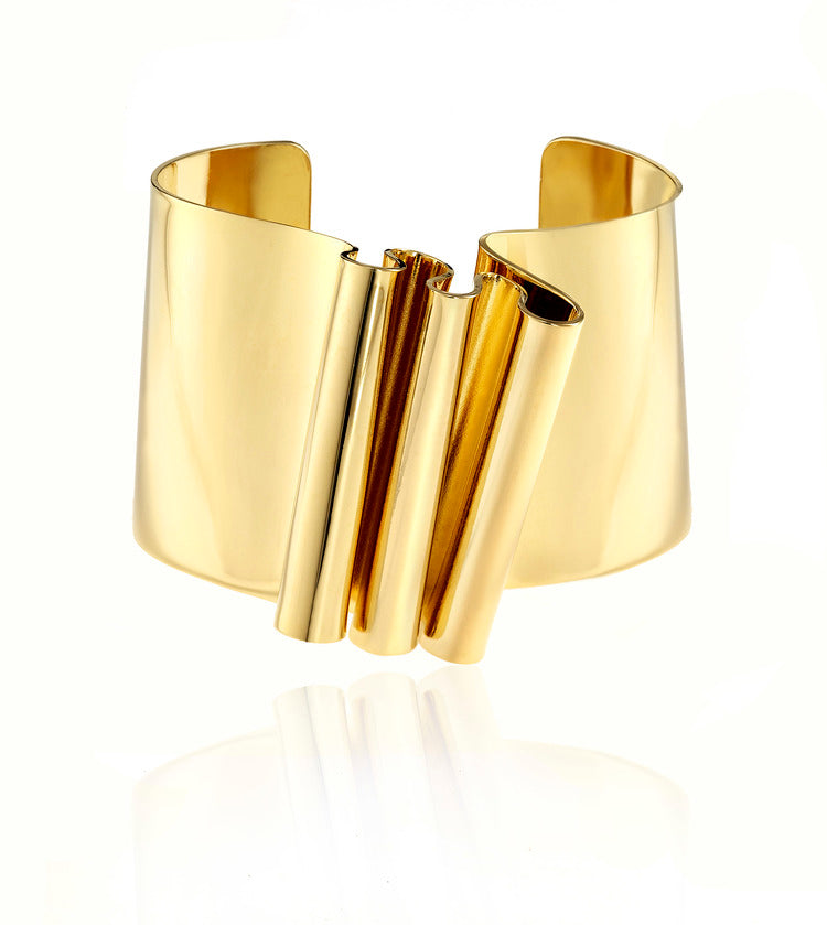 This is sculptural, yet not voluminous bracelet. Interesting ripple on the front surface makes this a unique cuff. It is an everyday piece, easy to wear and can be for playing dress up or just to bring out your inner Barbarella!  ~1.5" wide in size and it sits about .4" above with the ripples.   Each piece is handmade-please allow slight variance.  Hand fabricated in brass and finished with 14k nickel free gold plating. 